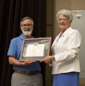 a man accepts a framed plaque